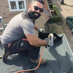 Portret van een dakdekker van Astrodak die op een dak aan het werk is