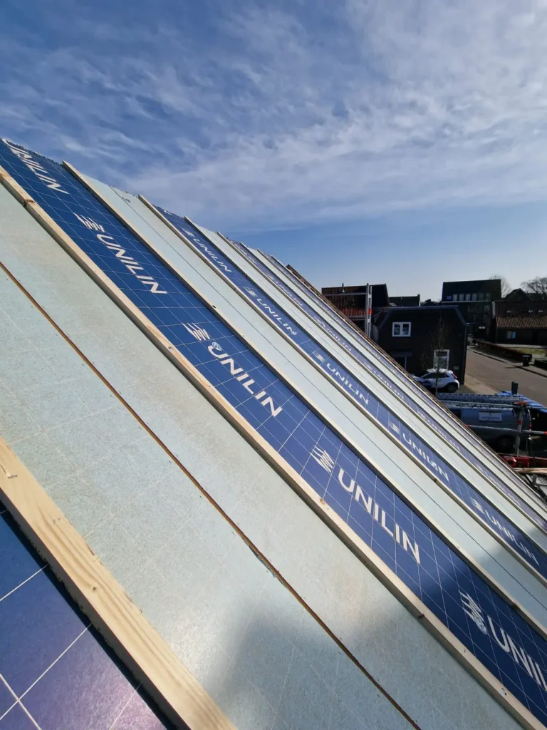 Hellend dak met Unilin isolatieplaten en een Astrodak bedrijfsbus op straat