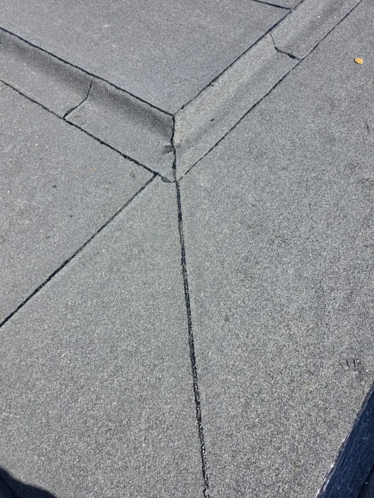 Detail van een plat dak met bitumineuze dakbedekking en afgewerkte naden in de hoek
