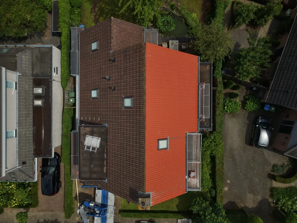 Luchtfoto van een woning met een compleet vernieuwd oranjerood pannendak, project in Esch